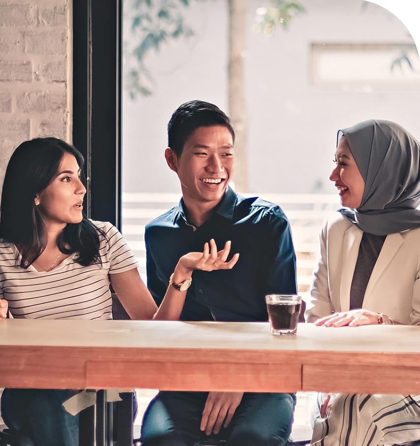 Three multicultural people talking at a coffee table