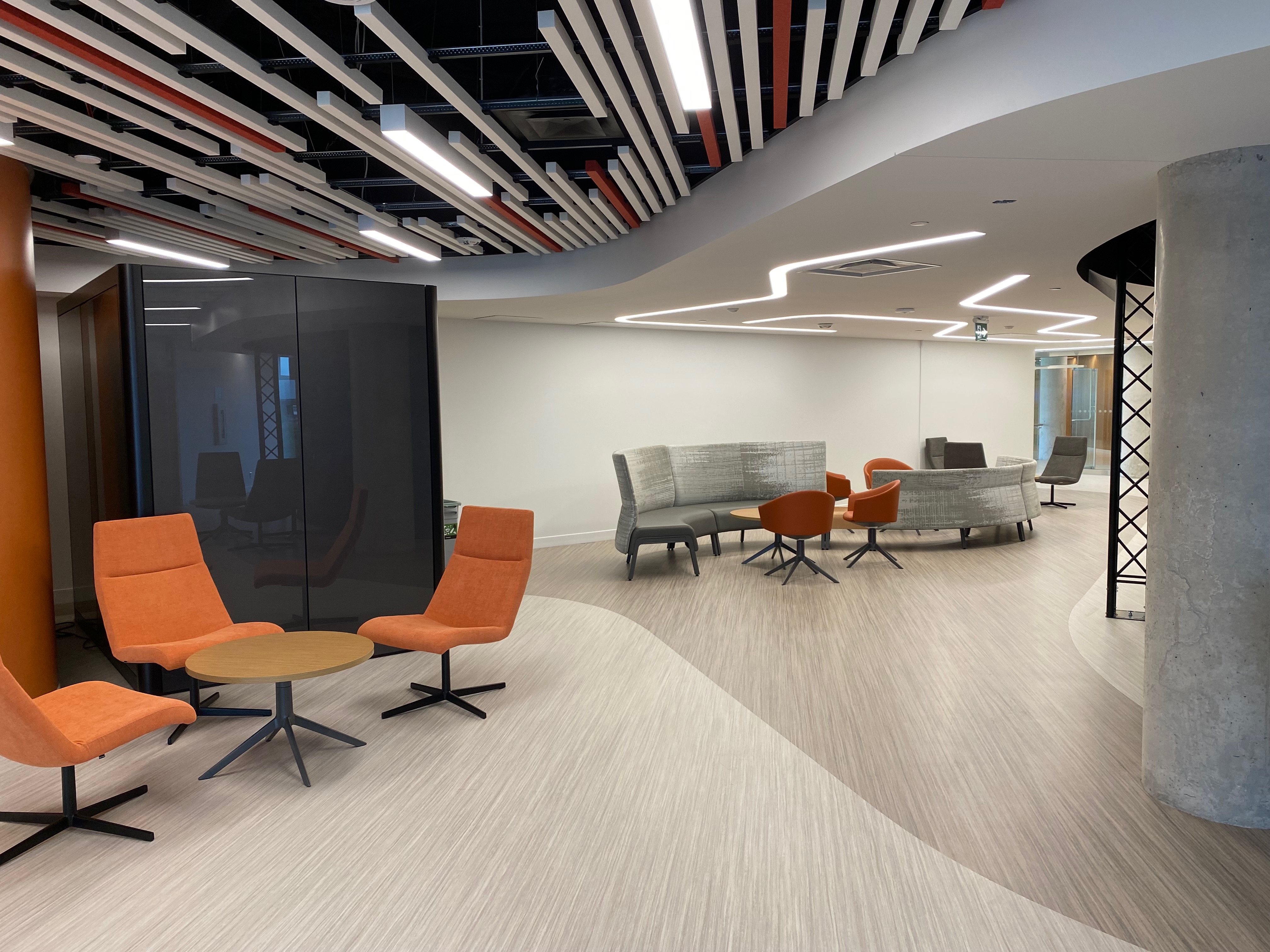 Photo salles de classe collaborative avec de grands écrans aux murs t des étudiantes et étudiants assis autour d'une table et