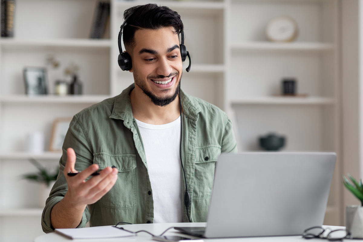 Un homme en consultation via un casque et son portable.